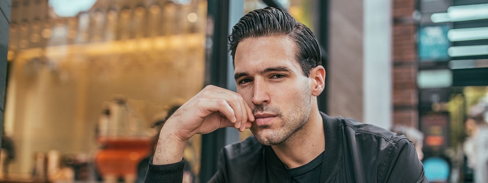 Man sitting thoughtfully at a café.