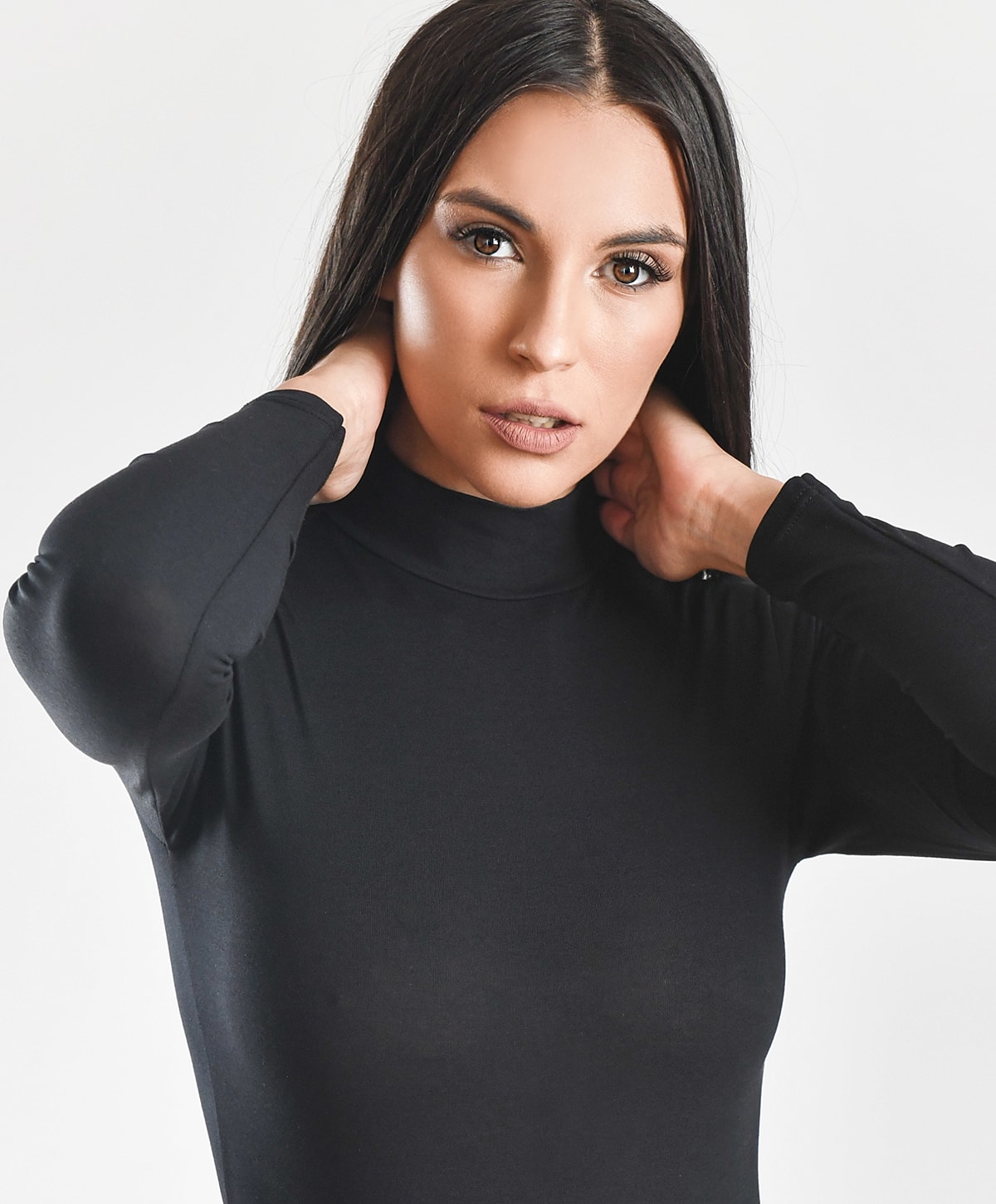 Woman in black turtleneck, posing thoughtfully.