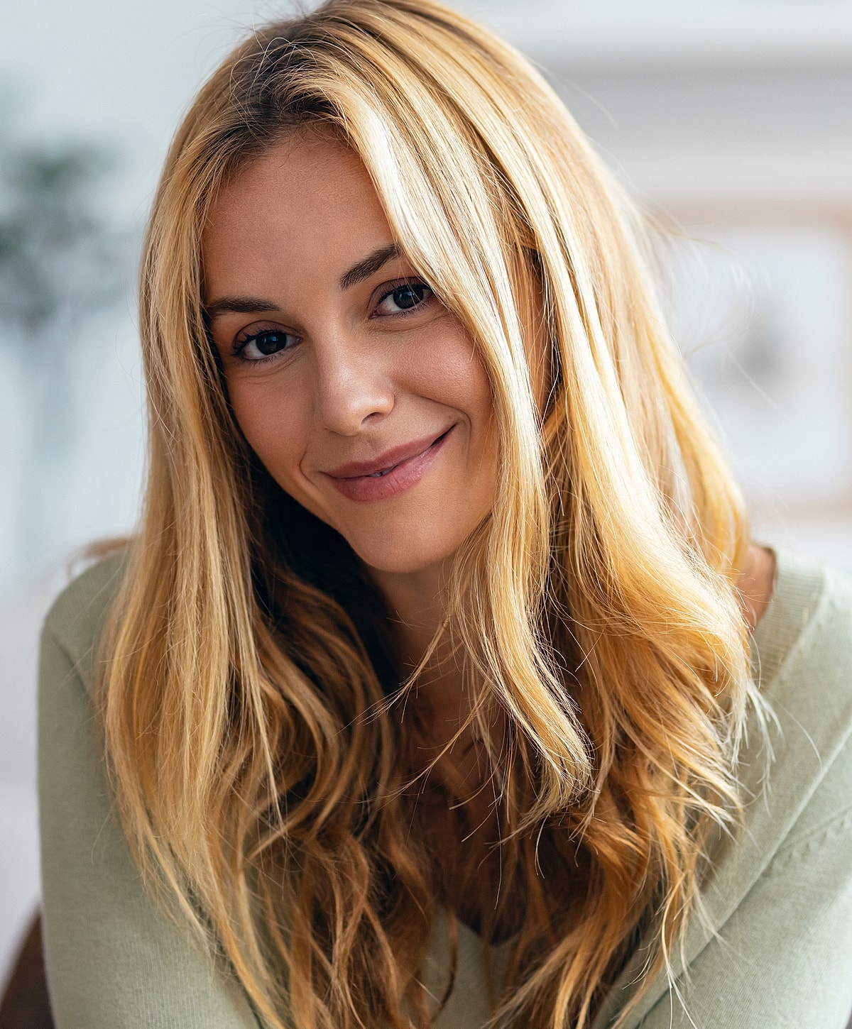 Smiling woman with long, wavy blonde hair.