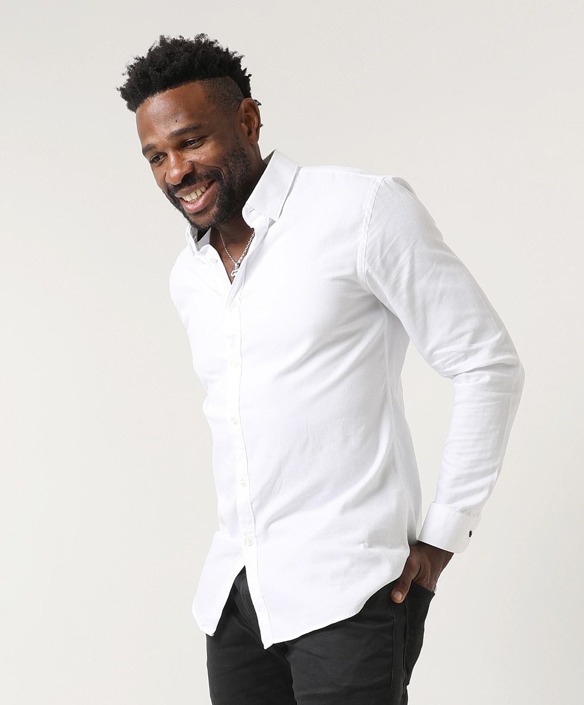 Smiling man in a white button-up shirt.