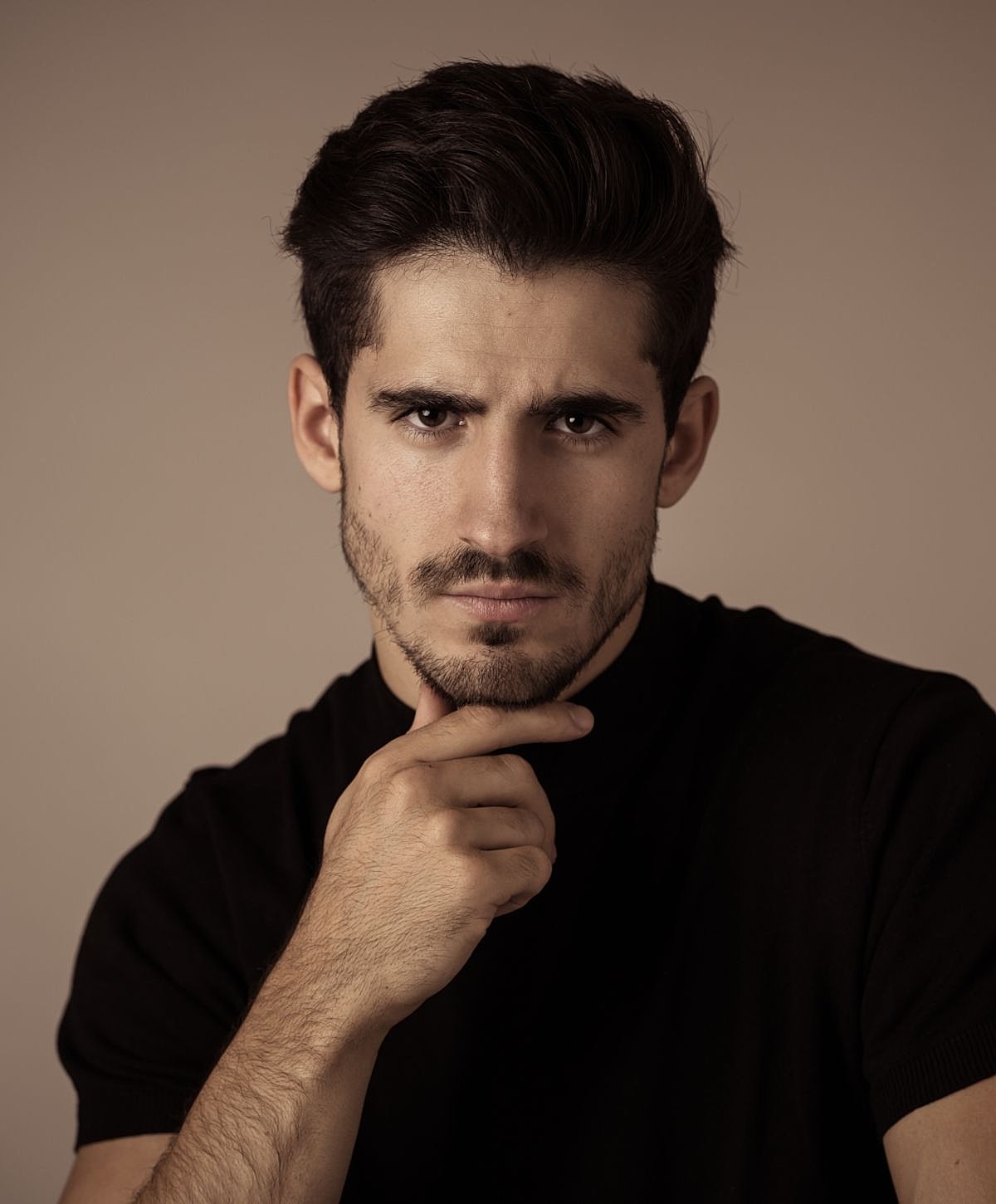 Man with thoughtful expression in studio lighting.