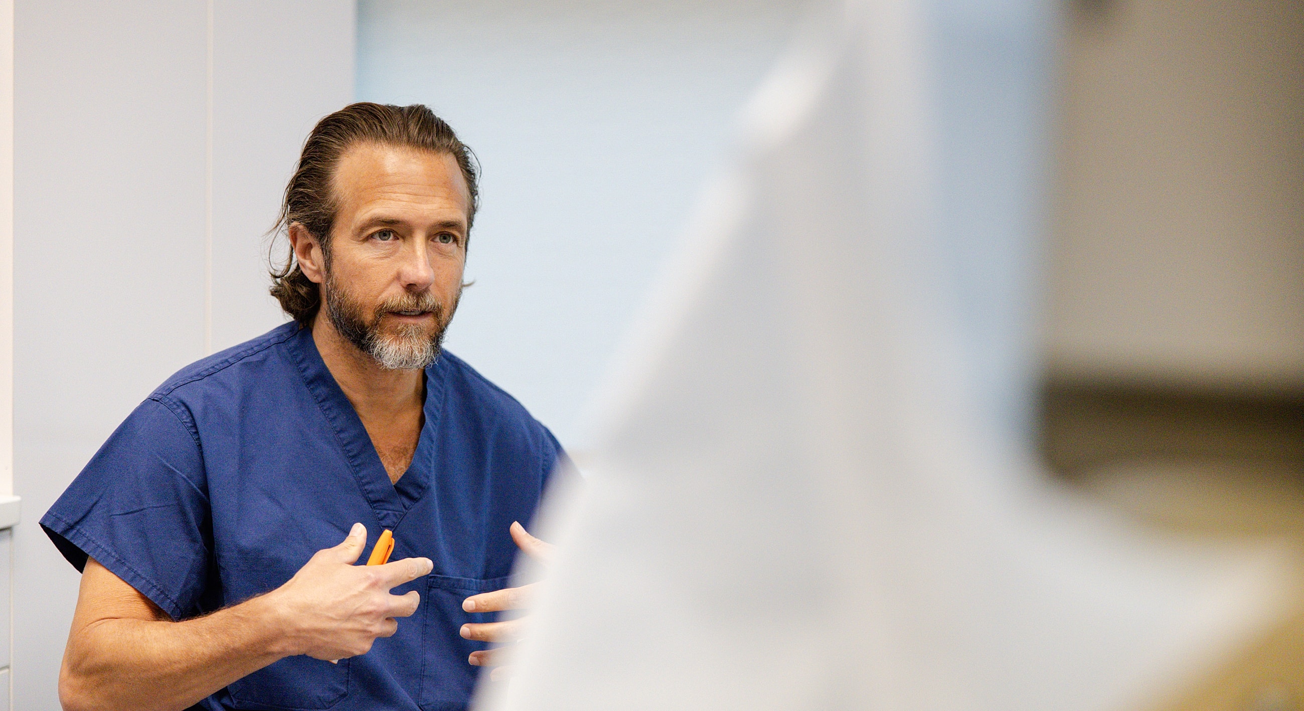 Man in scrubs discussing in medical setting