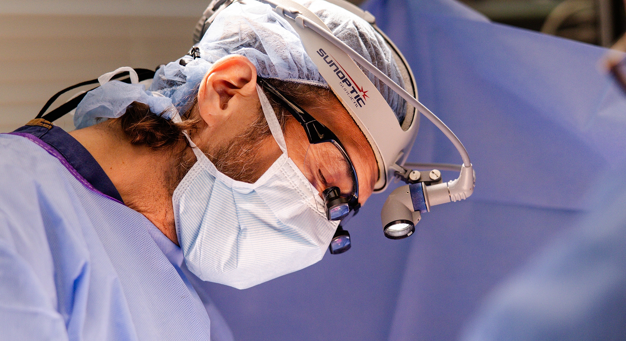 Surgeon focused on procedure in operating room.